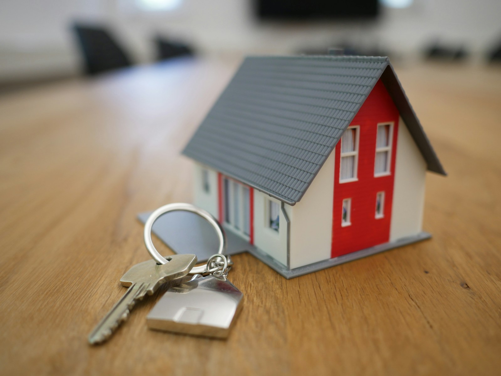 white and red wooden house miniature on brown table symbolizing homeowners insurance